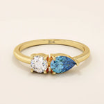 14k gold Toi et Moi ring with pear-shaped sapphire and round moissanite side by side. A symbolic two-stone engagement ring.