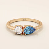 14k gold Toi et Moi ring with pear-shaped sapphire and round moissanite side by side. A symbolic two-stone engagement ring.