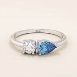 14k gold Toi et Moi ring with pear-shaped sapphire and round moissanite side by side. A symbolic two-stone engagement ring.