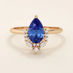 14k gold pear sapphire ring featuring white moissanite accents below the center stone. Elegant and timeless gemstone ring design.