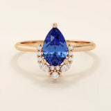 14k gold pear sapphire ring featuring white moissanite accents below the center stone. Elegant and timeless gemstone ring design.