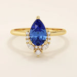 14k gold pear sapphire ring featuring white moissanite accents below the center stone. Elegant and timeless gemstone ring design.