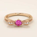 14k gold ribbon-shaped ring with a vibrant lab-grown ruby at the center. Elegant and romantic design with gemstone sparkle.