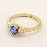 14k gold ring featuring a half bezel round sapphire with baguette moissanite accents. A modern gemstone anniversary band with elegant sparkle.