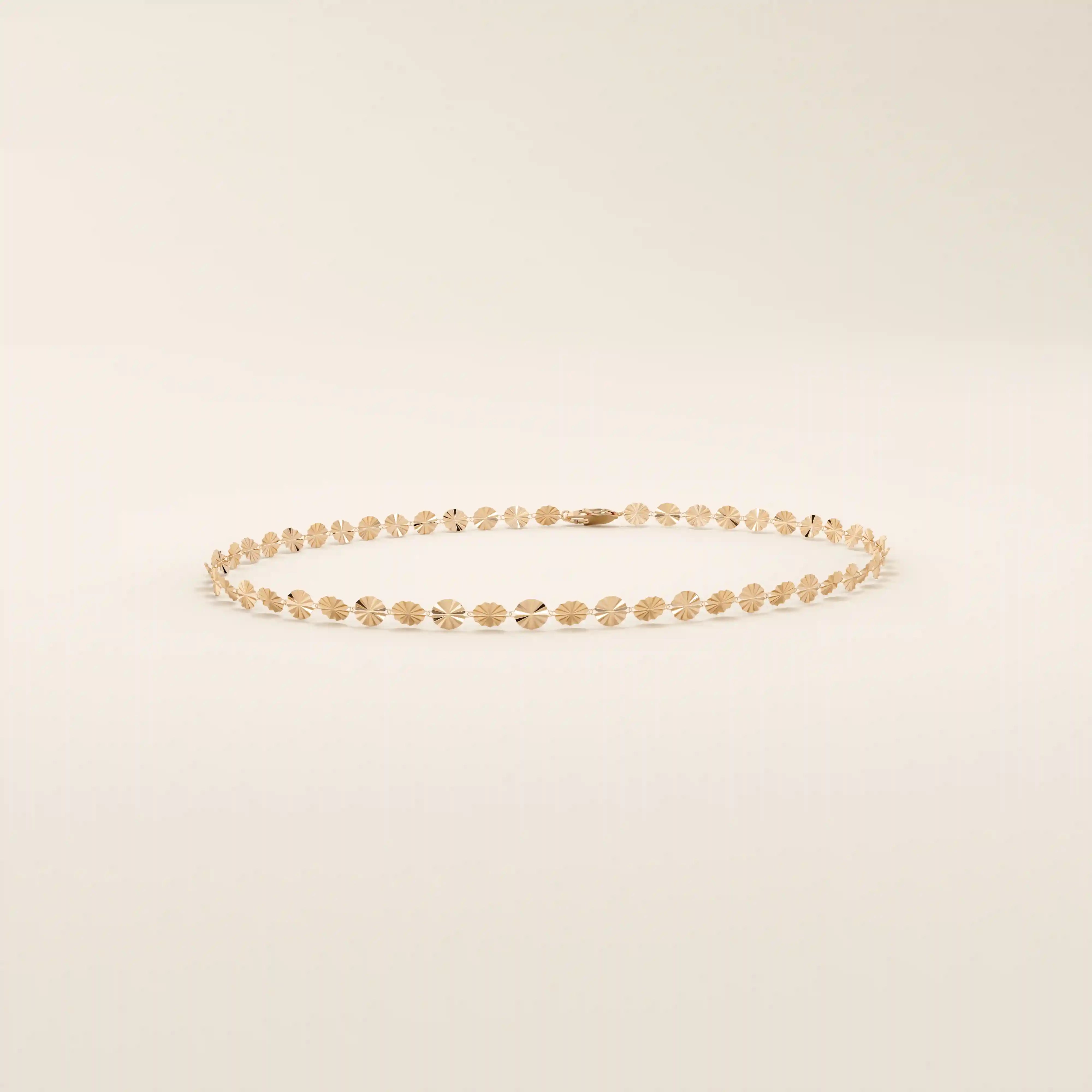 14k rose gold bracelet with delicate textured circle links in a shimmering starburst motif.
