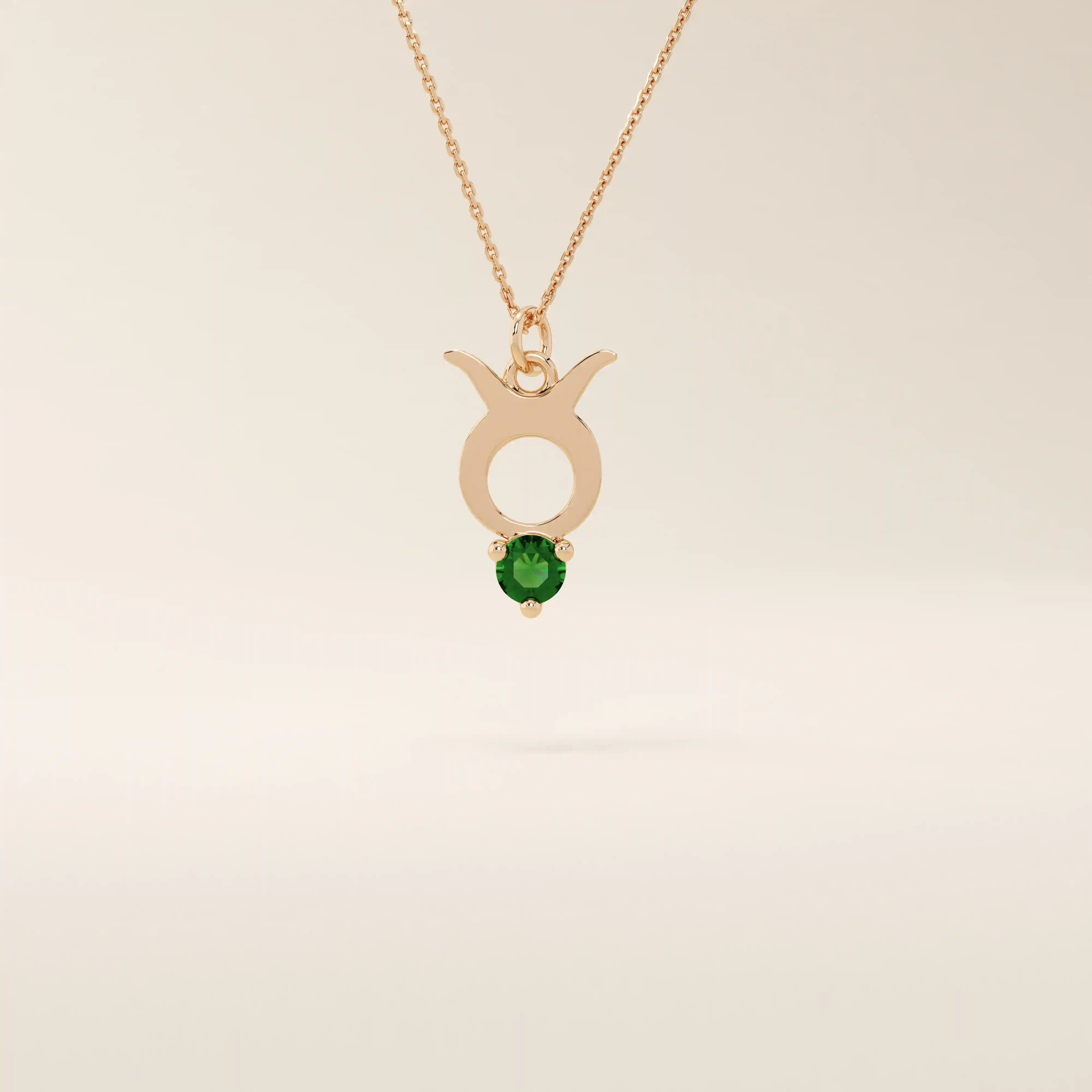 14k solid gold Taurus zodiac pendant necklace with a rich green emerald birthstone. A personalized and elegant zodiac accessory.