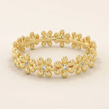 14k solid gold eternity band ring adorned with tiny daisy flower motifs. Delicate and whimsical statement jewelry for women.