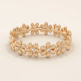 14k solid gold eternity band ring adorned with tiny daisy flower motifs. Delicate and whimsical statement jewelry for women.