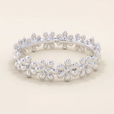 14k solid gold eternity band ring adorned with tiny daisy flower motifs. Delicate and whimsical statement jewelry for women.