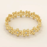 14k solid gold eternity band ring adorned with tiny daisy flower motifs. Delicate and whimsical statement jewelry for women.