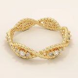 14k solid gold eternity statement ring with a unique twisted band design, adorned with sparkling moissanites. Elegant and modern.
