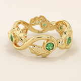 14k solid gold leaf vine band ring with a bezel-set emerald gemstone. Nature-inspired statement design.