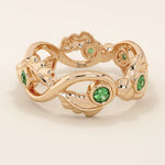 14k solid gold leaf vine band ring with a bezel-set emerald gemstone. Nature-inspired statement design.