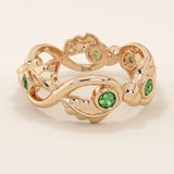 14k solid gold leaf vine band ring with a bezel-set emerald gemstone. Nature-inspired statement design.