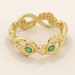 14k solid gold leaf vine band ring with a bezel-set emerald gemstone. Nature-inspired statement design.