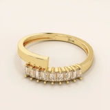 14k solid gold spiral statement ring with baguette-cut half eternity moissanites. Modern and elegant wrap-around design.