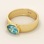 14k solid gold thick band ring with an oval cut topaz in a half bezel setting. Bold yet refined gemstone design. Perfect for stacking or solo wear.