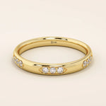 14k solid gold wedding band featuring a repeating trio moissanite pattern. A timeless and refined gold ring with subtle sparkle. Perfect for weddings or everyday wear.