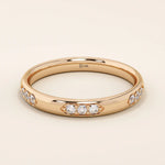 14k solid gold wedding band featuring a repeating trio moissanite pattern. A timeless and refined gold ring with subtle sparkle. Perfect for weddings or everyday wear.