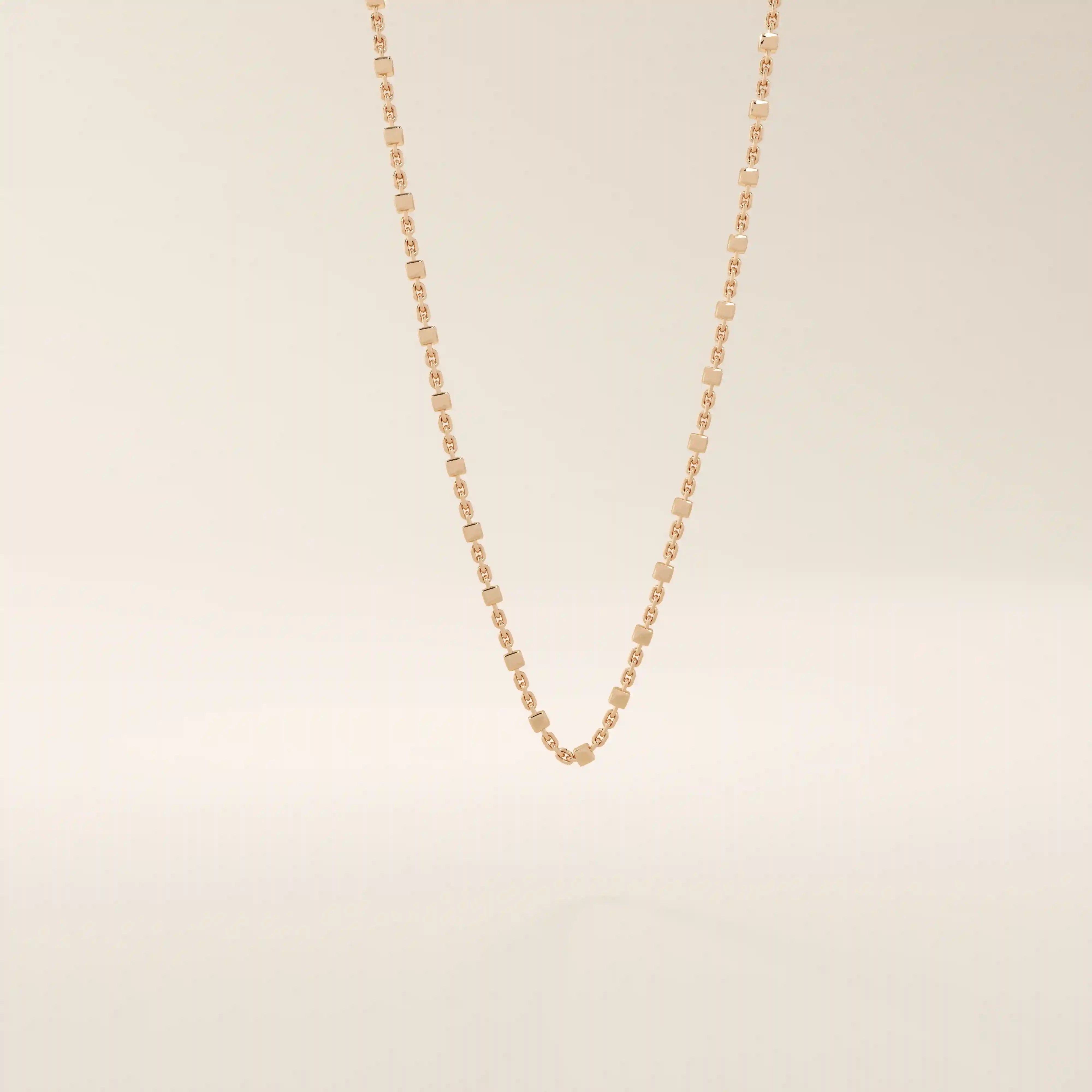 14k solid rose gold dot chain necklace showcasing flat square accents placed at regular intervals, blending warm tones with a contemporary, understated elegance.