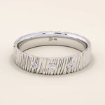 14k solid white gold wide wedding band with a wood grain texture and three bezel set round brilliant cut moissanite stones, distinctive and modern statement ring