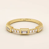 14k solid yellow gold band featuring a baguette cut moissanite center stone flanked by round brilliant cut moissanite accents, modern bezel and prong setting fine jewelry