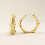 14k solid yellow gold bone-inspired hoop earrings with sculptural curves and angular edges, offering a bold and artistic statement design.