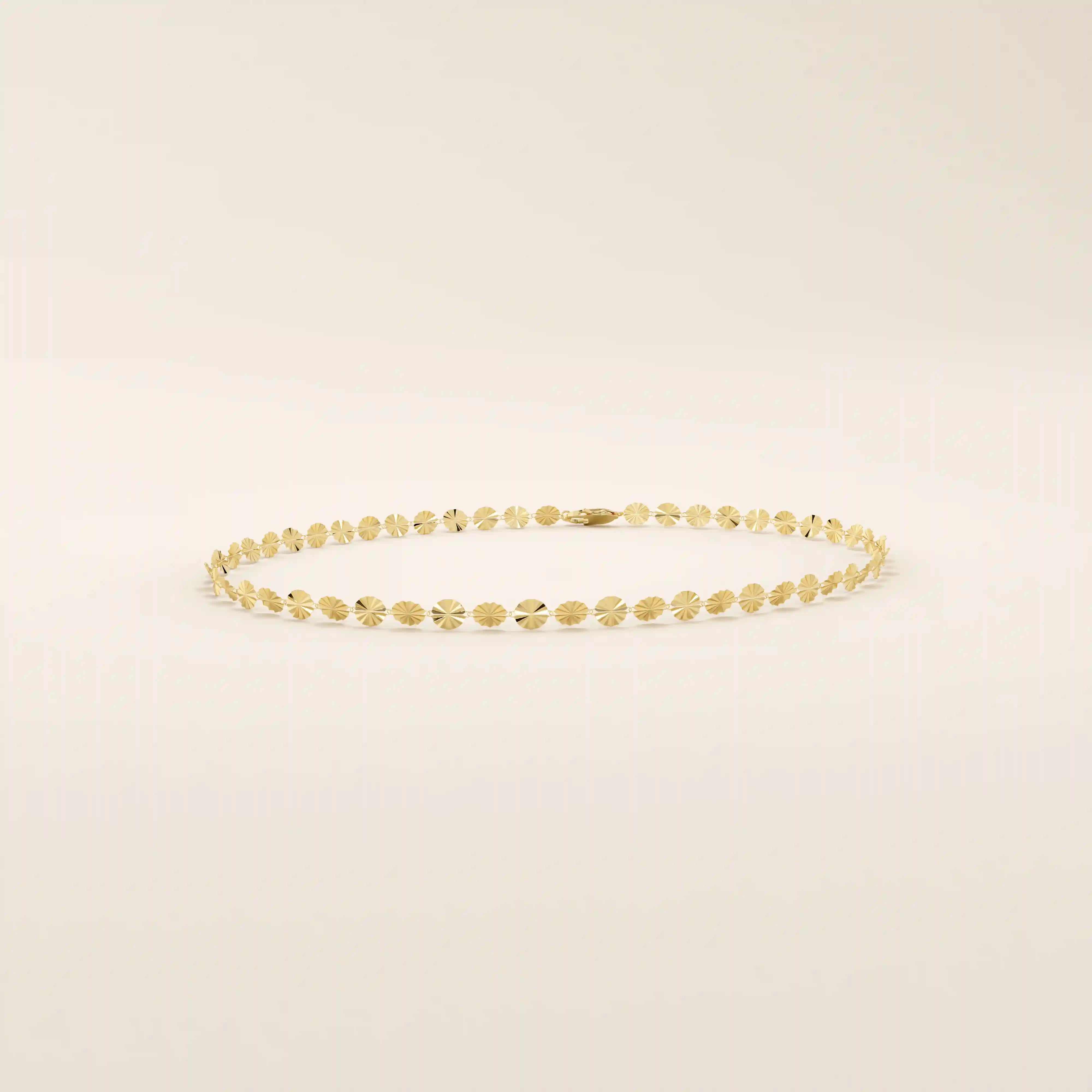 14k yellow gold bracelet with textured circular links featuring a starburst pattern.