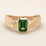 A vintage-style statement ring crafted in 14k solid gold, featuring a bezel-set emerald cut green gemstone at the center. The rectangular stone sits vertically on a thick polished gold band.
