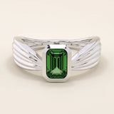 A vintage-style statement ring crafted in 14k solid gold, featuring a bezel-set emerald cut green gemstone at the center. The rectangular stone sits vertically on a thick polished gold band.