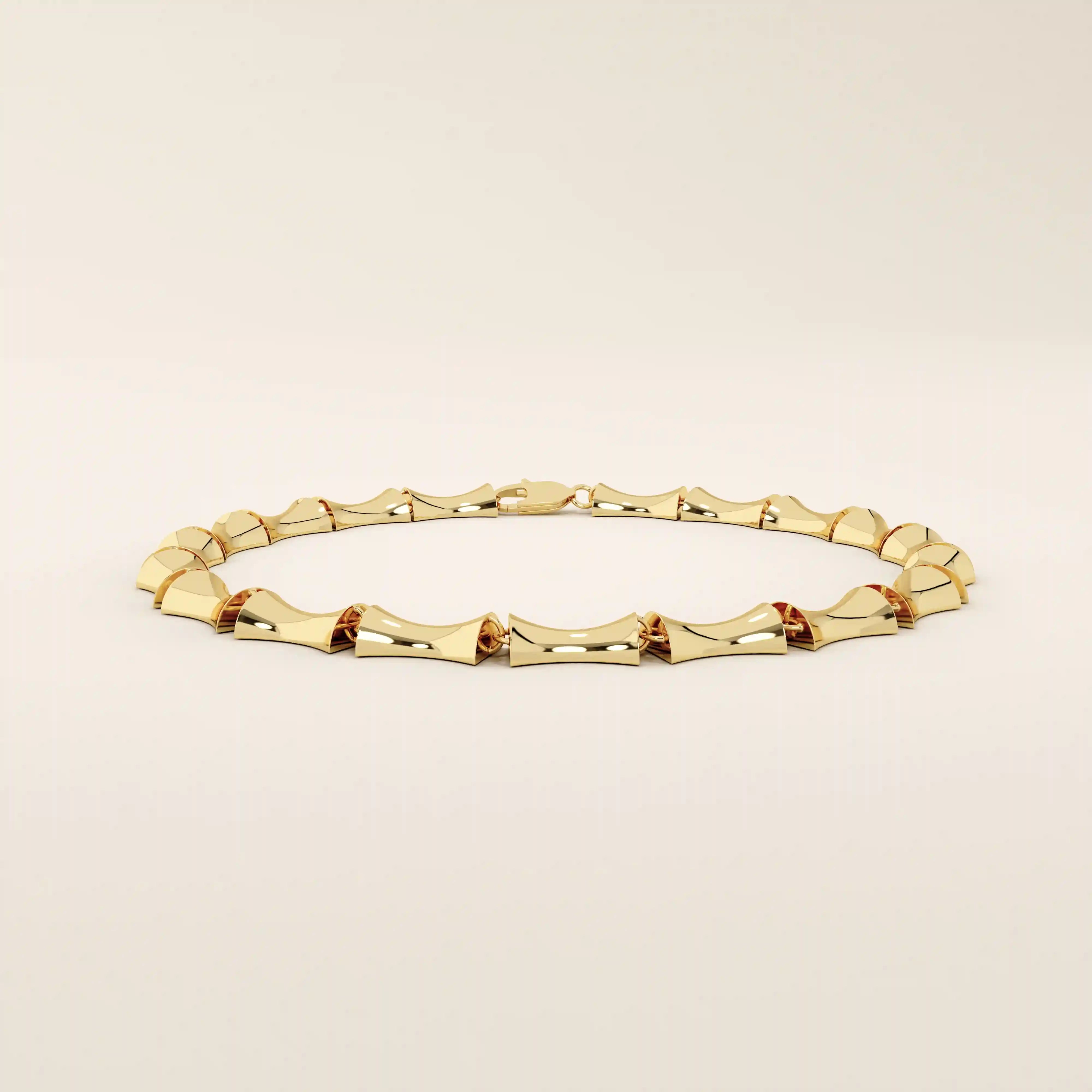 Angled view of a 14k yellow gold bone bracelet highlighting its thick, sculpted links with a glossy curved finish.