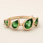Bold 14k gold ring with five pear-cut emerald gemstones. A vibrant and eye-catching statement ring with rich green tones.