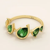 Bold 14k gold ring with five pear-cut emerald gemstones. A vibrant and eye-catching statement ring with rich green tones.