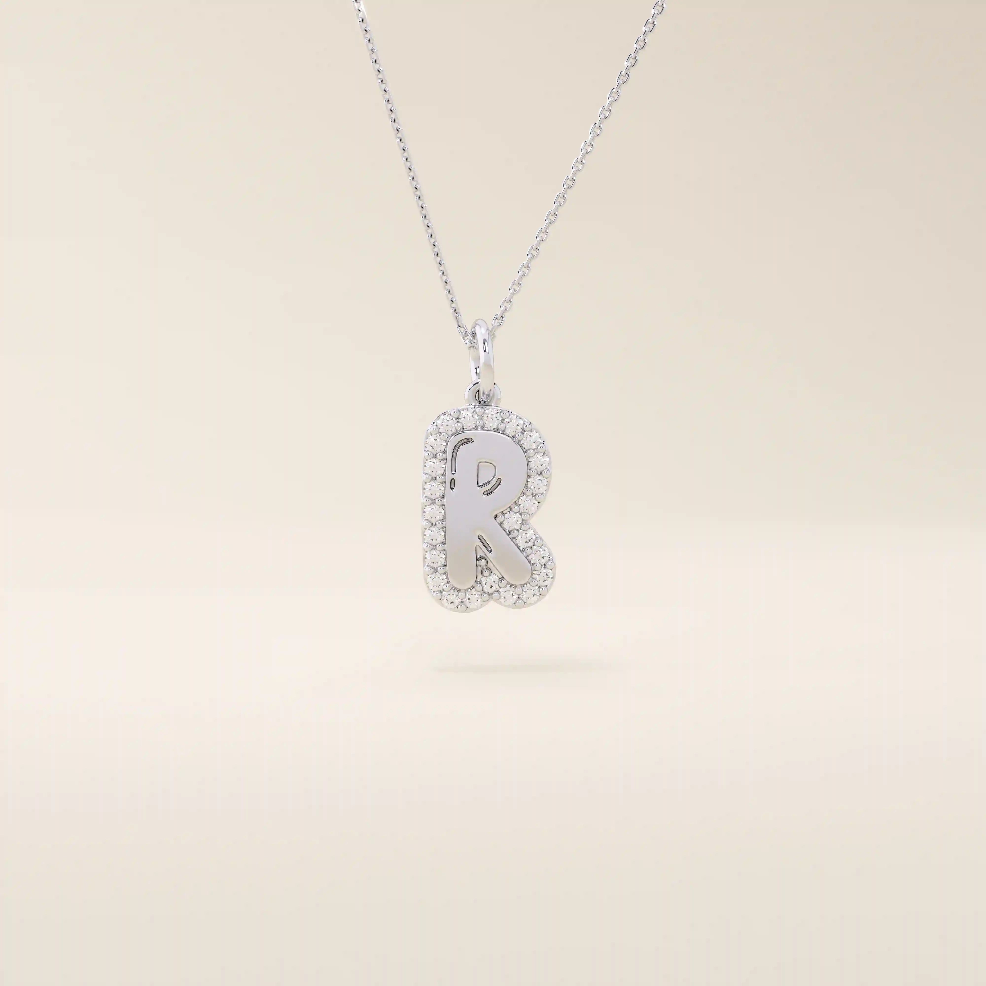 Bubble font initial pendant in 14k solid gold, framed with a halo of shimmering moissanites. A bold yet playful personalized necklace.