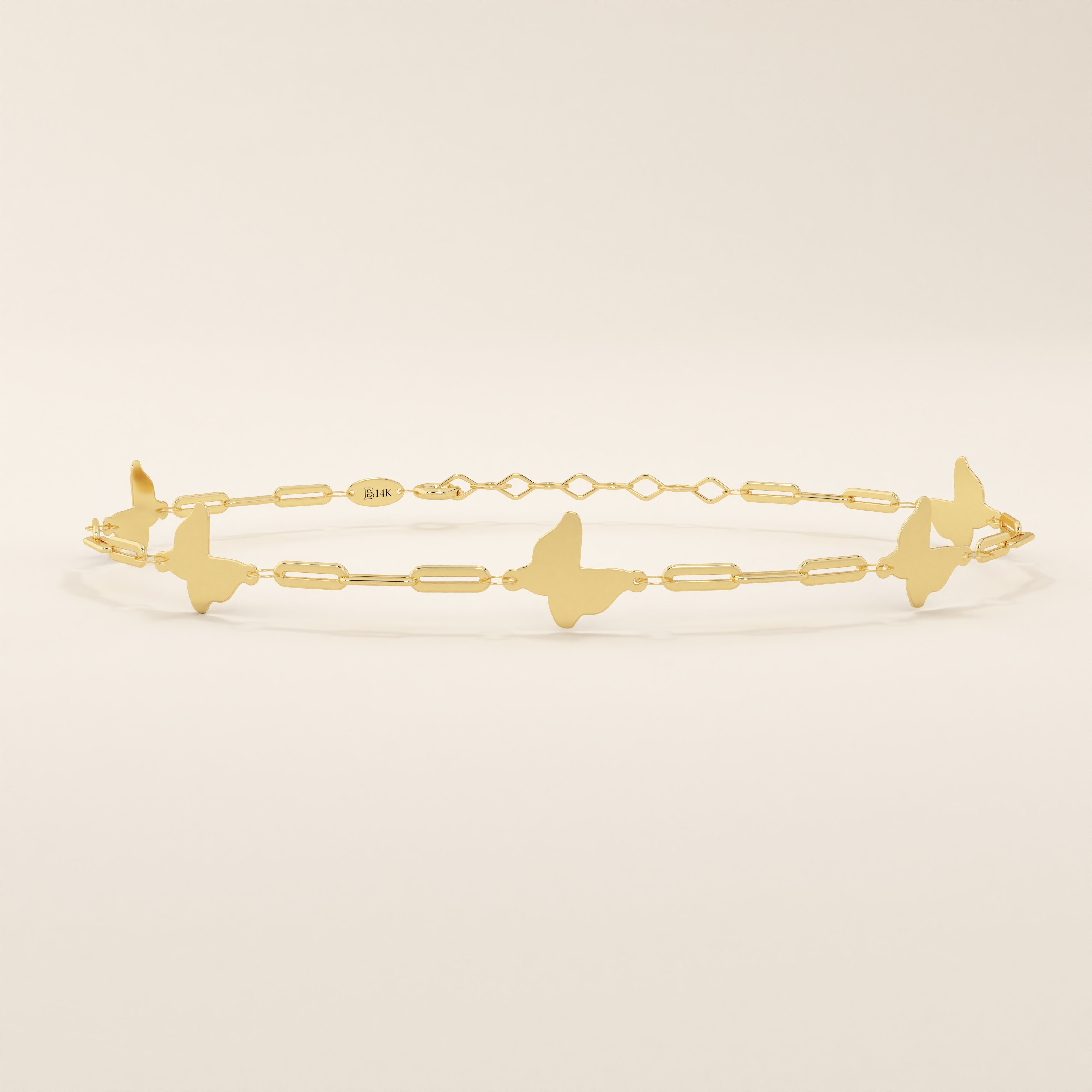 Close-up of a 14k yellow gold butterfly bracelet highlighting the polished butterfly charms and rectangular chain links.