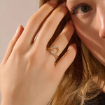Close-up of a model’s hand wearing a 14k yellow gold starburst ring with moissanite center and accent stones.