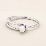 Minimalist 14k solid gold split band promise ring featuring a single lustrous pearl. Elegant design perfect for everyday wear or special occasions.