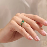 Model showcasing a 14k gold statement ring set with five pear-shaped emeralds. Striking and colorful gemstone ring perfect for standout looks.