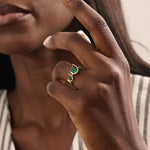 Model showcasing a 14k gold statement ring set with five pear-shaped emeralds. Striking and colorful gemstone ring perfect for standout looks.