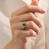 Model showcasing a 14k gold statement ring set with five pear-shaped emeralds. Striking and colorful gemstone ring perfect for standout looks.