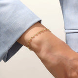 Model wearing a 14k gold textured chain bracelet, elegant with shimmering starburst accents.