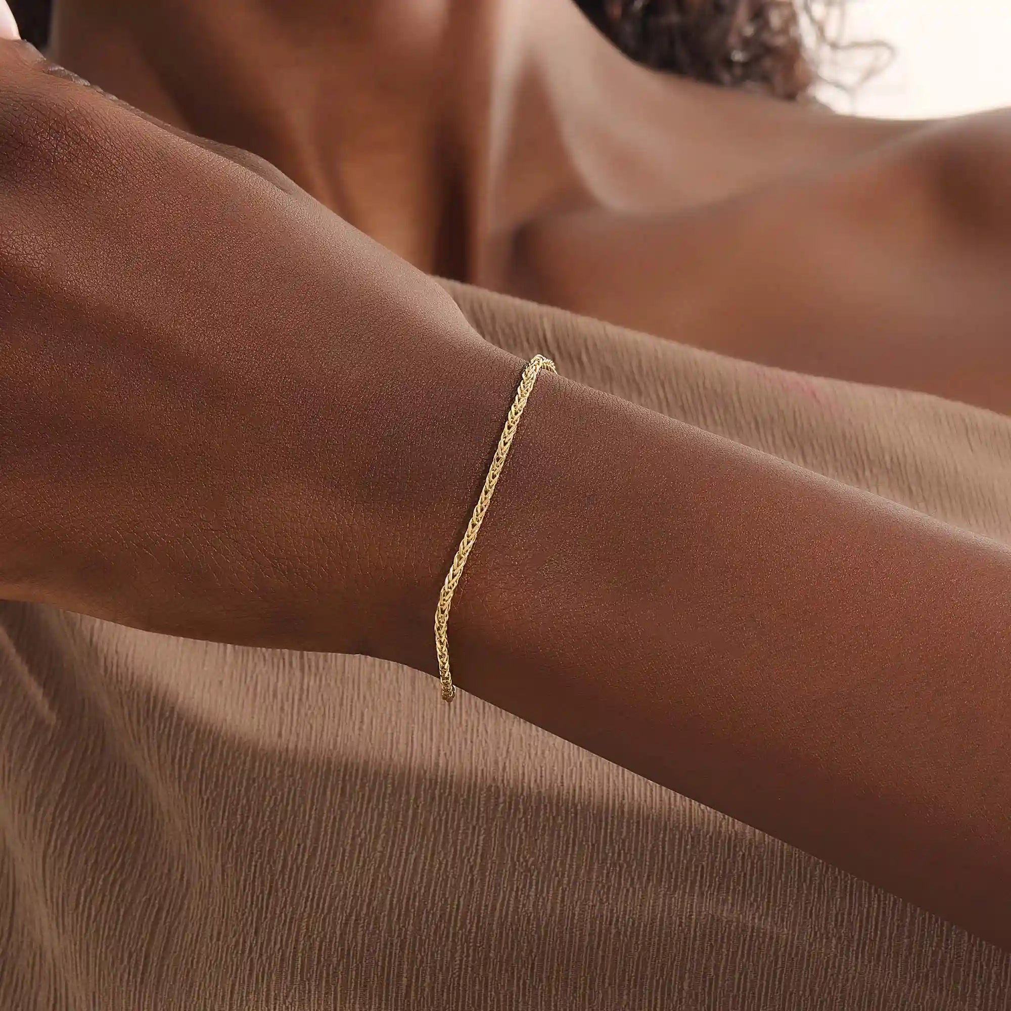 Model wearing a 14k gold wheat chain bracelet, a refined and minimal everyday accessory.