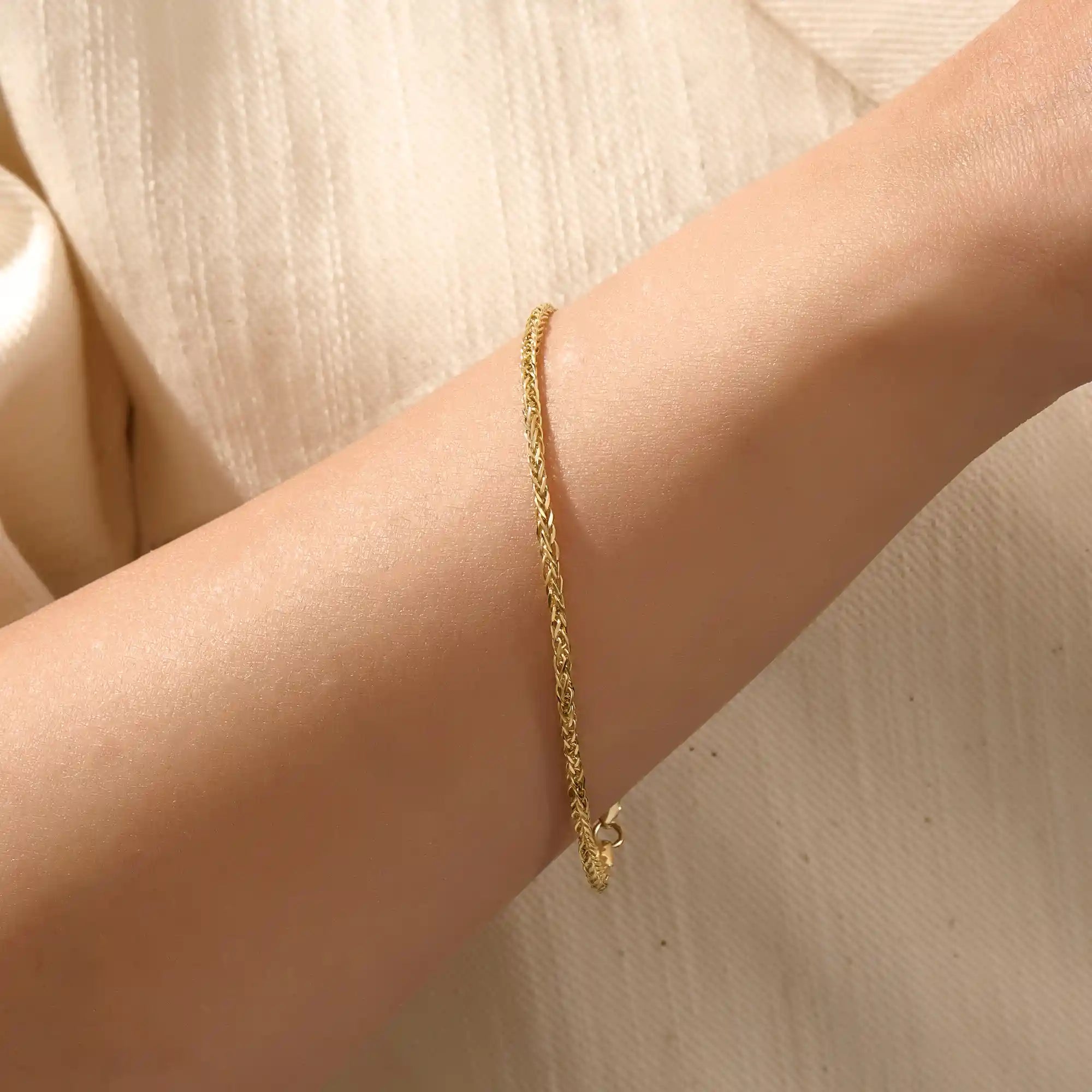 Model wearing a 14k gold wheat chain bracelet, a refined and minimal everyday accessory.