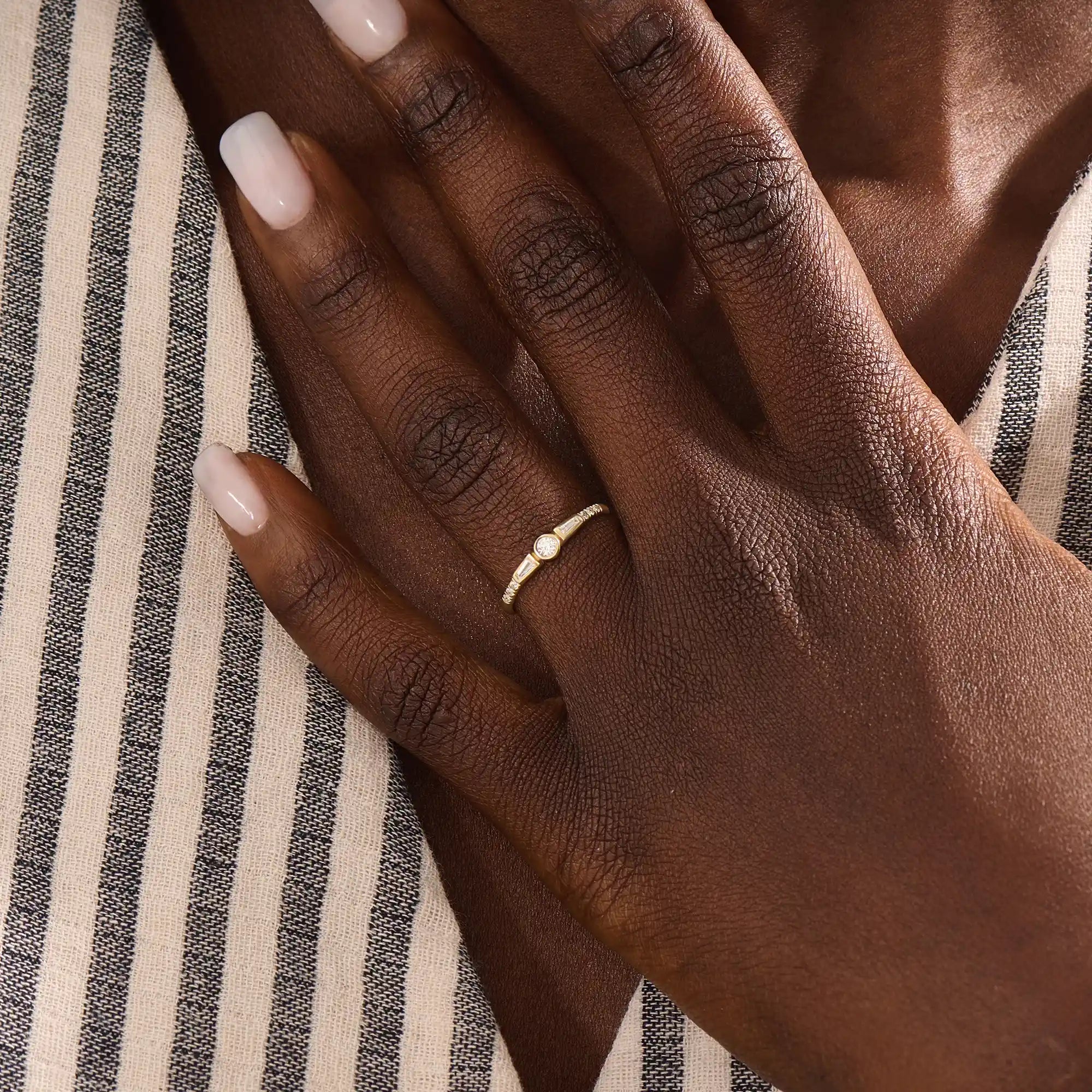 Model wearing a 14k solid gold bezel mixed cut promise ring, showcasing its sparkling moissanite stones and modern, elegant style.