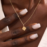 Model wearing a 14k solid gold clover motif necklace with a polished plain four-leaf pendant, adding timeless charm and minimalist style to any outfit.