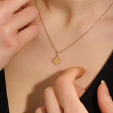 Model wearing a 14k solid gold clover motif necklace with a polished plain four-leaf pendant, adding timeless charm and minimalist style to any outfit.