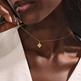 Model wearing a 14k solid gold clover motif necklace with a polished plain four-leaf pendant, adding timeless charm and minimalist style to any outfit.