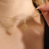 Model wearing a 14k solid gold clover motif necklace with a polished plain four-leaf pendant, adding timeless charm and minimalist style to any outfit.