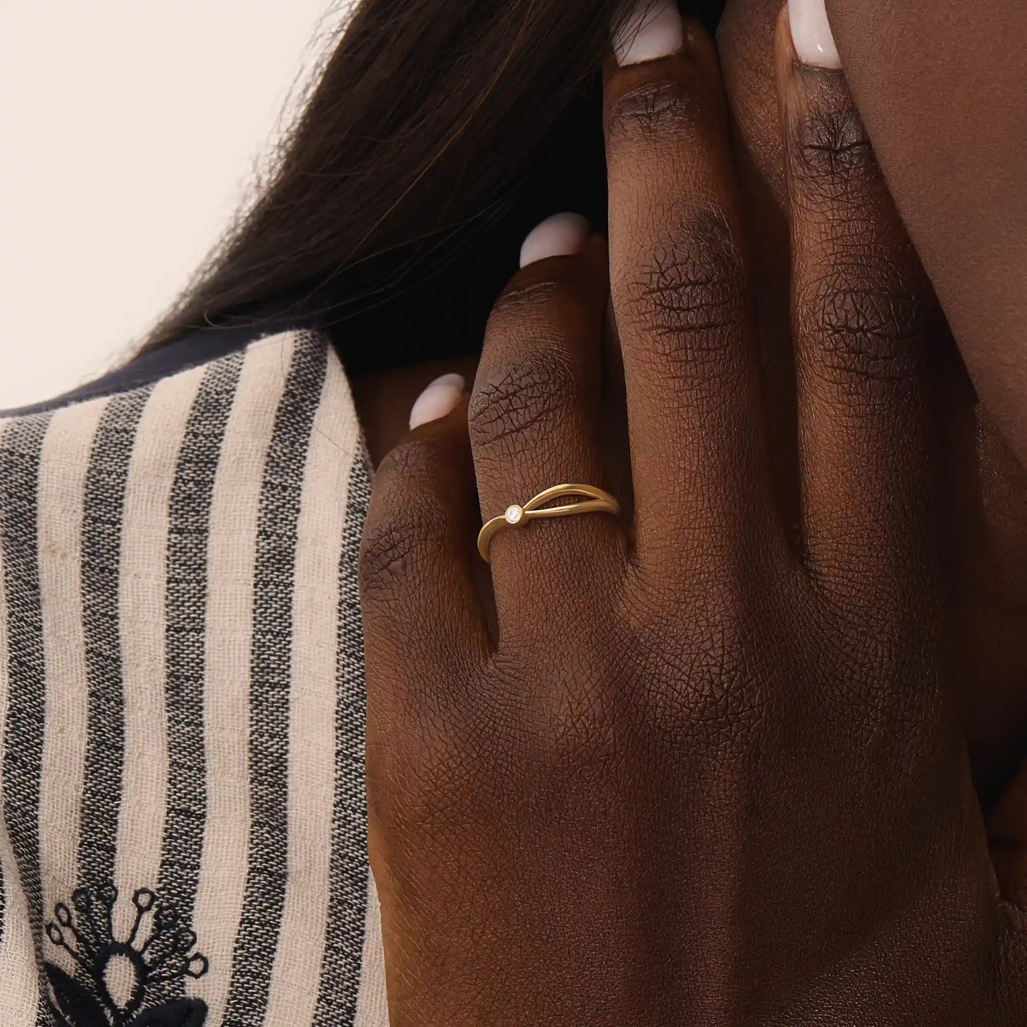 Model wearing a 14k solid gold split band promise ring with a delicate moissanite accent, showcasing a sleek and contemporary minimalist style.