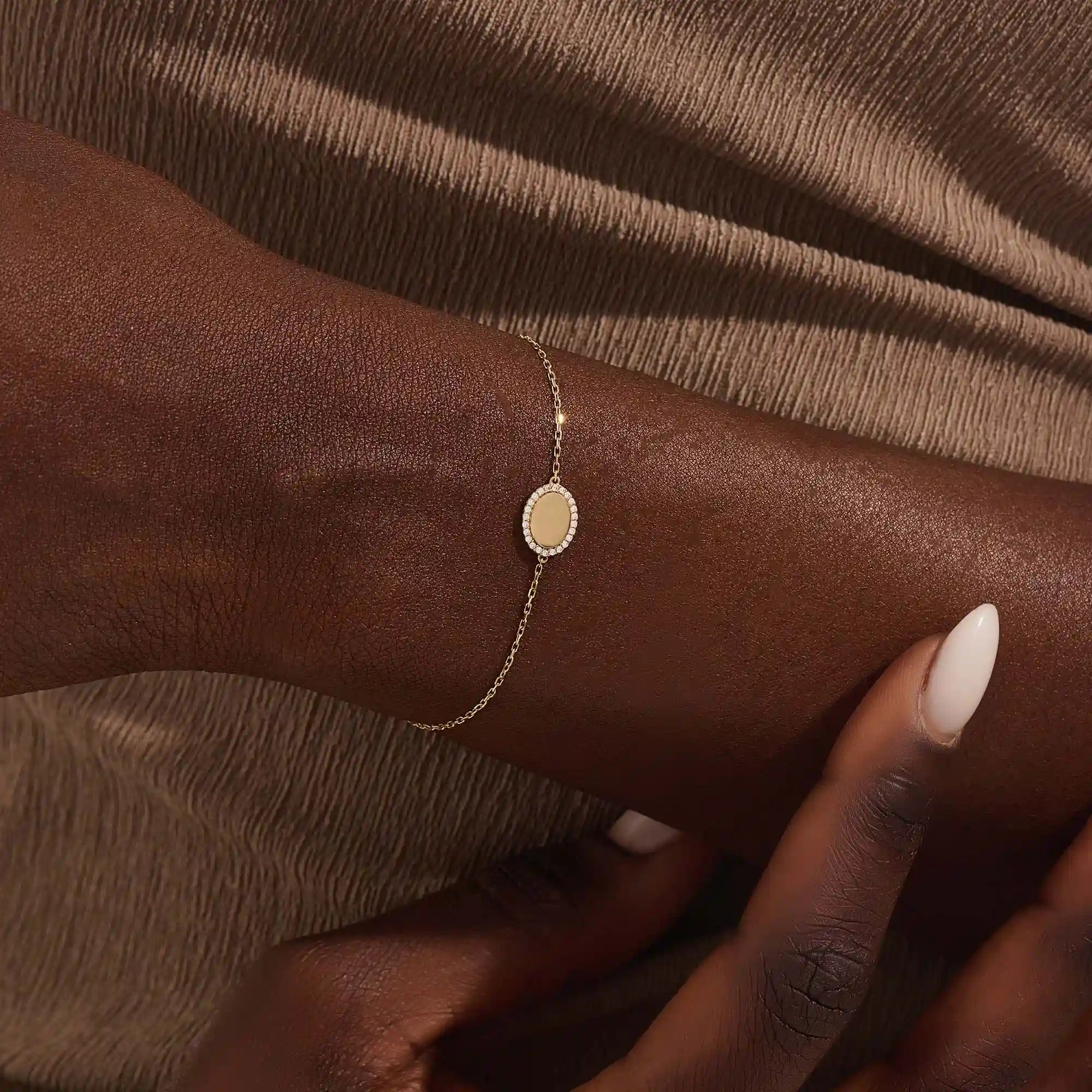 Model wearing a 14k yellow gold oval bracelet with pavé moissanite halo, adding refined sparkle to the wrist.